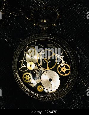 Time gone by - lost opportunities symbolised in a broken pocket watch full of old cogs Stock Photo