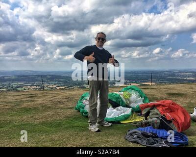 Man giving thumbs up after landing his paraglider Stock Photo