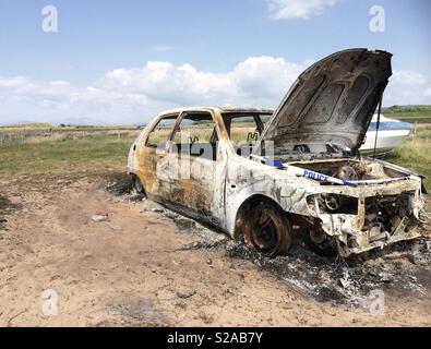 A burnt out car down a local beach Stock Photo