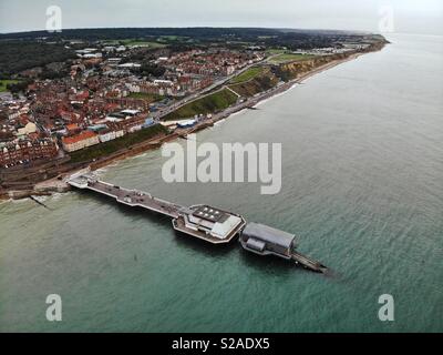 Aerial shot of Cromer pier from out to sea looking towards the town at dusk. Stock Photo