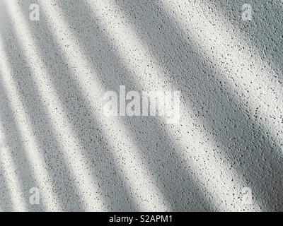 Shadow stripes on a structured wall Stock Photo
