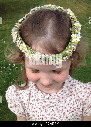 Six-year-old girl with a daisy chain on her head, in the shape of a crown. Stock Photo