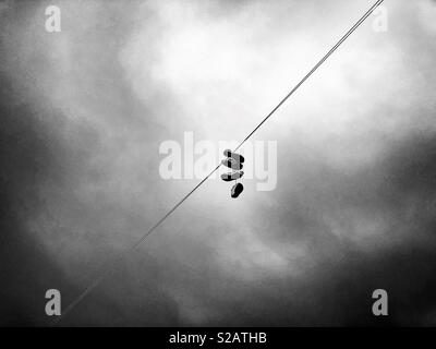 Two pairs of trainers hanging on a telephone line in Cardiff. Stock Photo