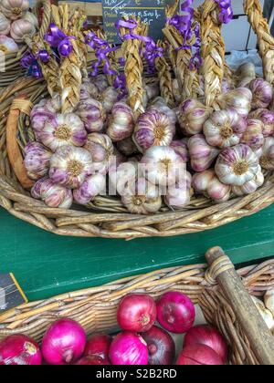 Garlic cloves and onions for sale at an outdoor market in southern France. Stock Photo