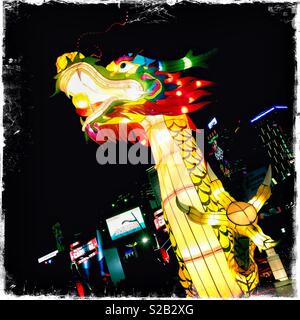 A large illuminated dragon sculpture celebrating Chinese New Year at a funfair at Hong Kong Island's Central district waterfront Stock Photo