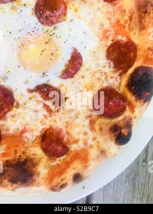 Pepperoni pizza with fried egg Stock Photo