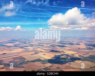 Areal view of farms under a blue a September sky, with white clouds casting shadows below. Stock Photo
