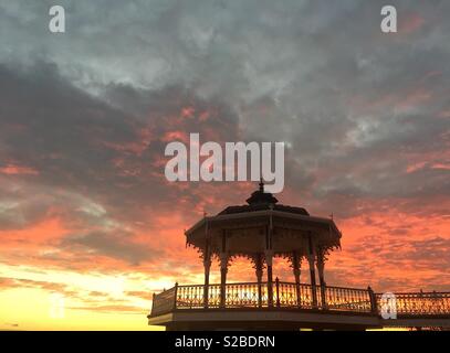 Fiery sunset behind a band stand on the promenade in Brighton, East Sussex Stock Photo