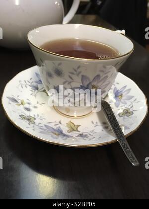 Vintage cup and saucer with spoon filled with tea