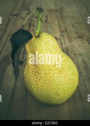 Ripe green pear with rad on wooden table Stock Photo
