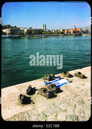 The ‘Shoes on the Danube Bank’, Budapest, Hungary. The trail of iron shoes is a memorial to Jews shot here by Arrow Cross militiamen in WW2. Stock Photo