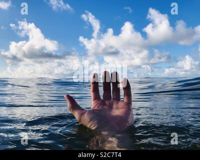 A hand floating in water. Hanalei Bay, Kauai, USA.