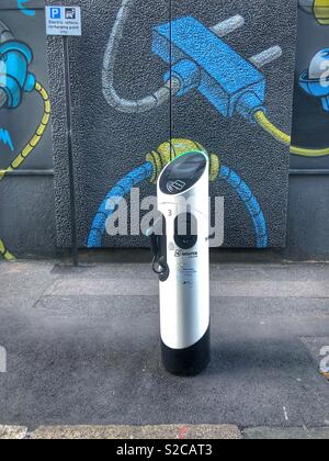 Electric car charger on pavement in shoreditch, east London, Britain. In front of street art mural. No people. Stock Photo