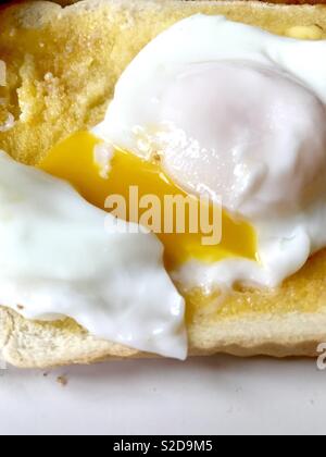 Perfect runny poached egg on toast Stock Photo