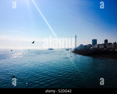 A photograph of Brighton seafront taken from the pier on a hot summer’s evening. Brighton UK Stock Photo