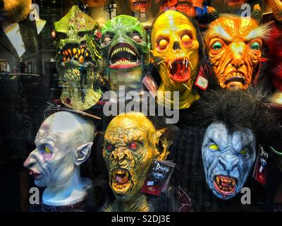 Scary masks for sale in a shop window. It must be Halloween time?! Photo Credit - © COLIN HOSKINS. Stock Photo