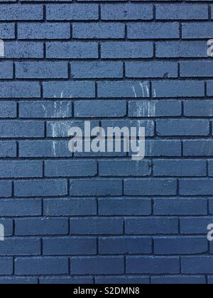 White handprints on a black/blue brick wall Stock Photo