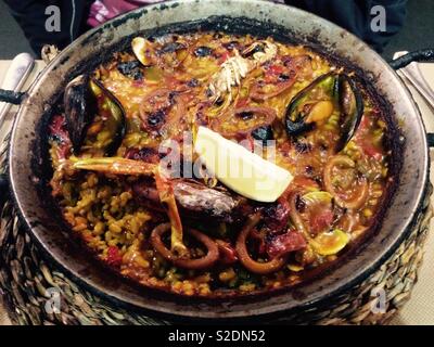 Seafood paella served in authentic paella pan in restaurant in Barcelona Spain Stock Photo