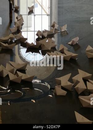 Paper boats in a cistern art piece Stock Photo