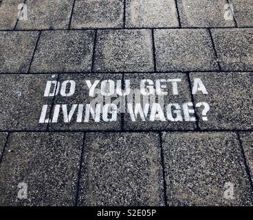 Do you get a living wage? Stencilled onto a city street Stock Photo