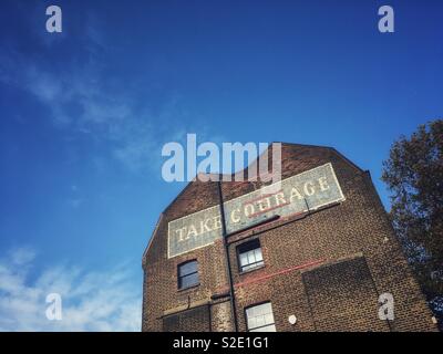 Take Courage Advert on What used to be The Courage & Co. Ltd Brewery in Southwark London in England Stock Photo