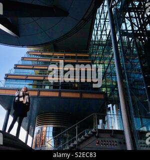 Young woman standing in front of modern architecture at Potsdamer Platz, Berlin, Germany. Stock Photo