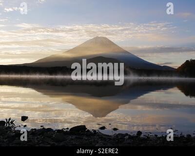 Mount Fuji at Sunrise reflected in the waters of Lake Shoji in Autumn Stock Photo