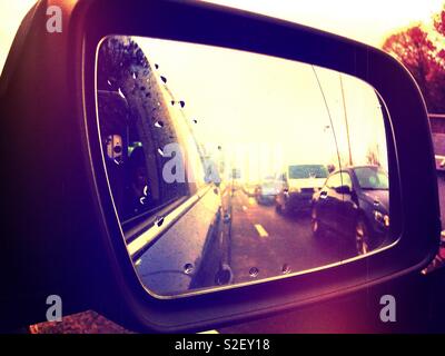 Looking back at stationary traffic in a car wing mirror. Stock Photo