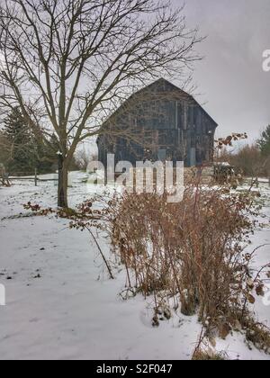 Winters old weathered barn, on a snow covered farm, rural area.