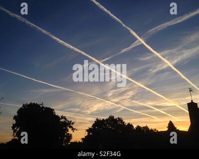 Early morning rush hour in the skies above Sussex, England. Airplane contrails in all lanes. Stock Photo