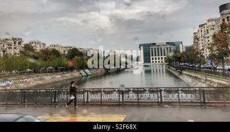 Looking through a bus window while driving through the Bucharest on a rainy day. Stock Photo