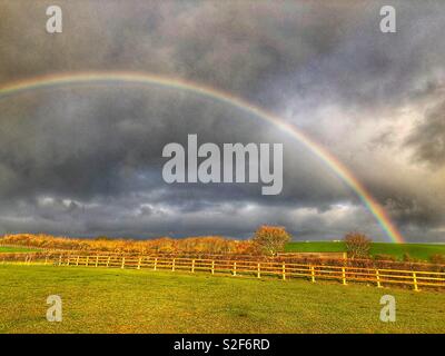Rainbow and storm clouds over pasture fields, Kingsdon, Somerset, UK Stock Photo