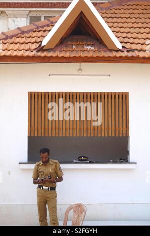 Indian police officer standing in front of a hut Stock Photo
