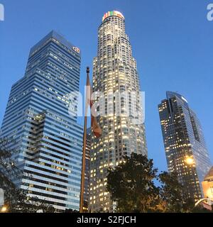 US Bank Tower, Citi Bank and Deloitte skyscrapers in Financial District of Downtown Los Angeles with California flag in foreground at dusk Stock Photo