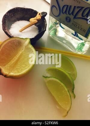 Still life of margarita ingredients, tequila limes and salt Stock Photo