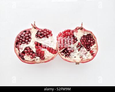 Pomegranate fresh fruit cut into two halves isolated on white background Stock Photo