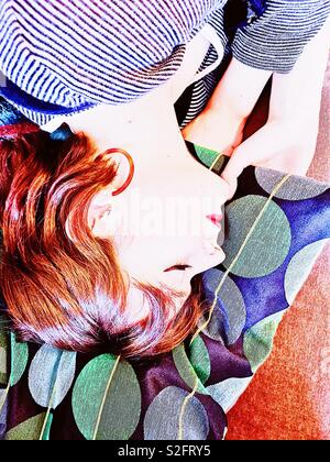 Upside down shot of beautiful auburn haired young woman sleeping Stock Photo