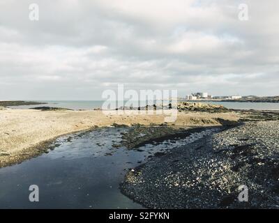 Cemlyn nature reserve, looking toward Wylfa nuclear Power Station from the weir. North Wales, Anglesey Area of Outstanding Beauty Stock Photo