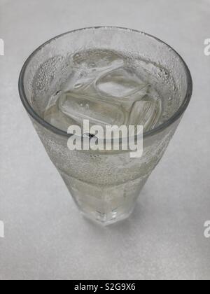 Glass of refreshing soda water with ice cubes on black background Stock ...