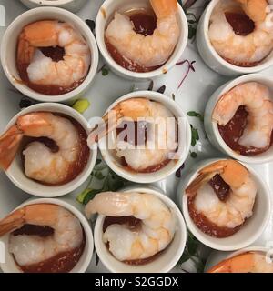 Overhead view of shrimp (prawns) served in ceramic bowls with red cocktail sauce Stock Photo