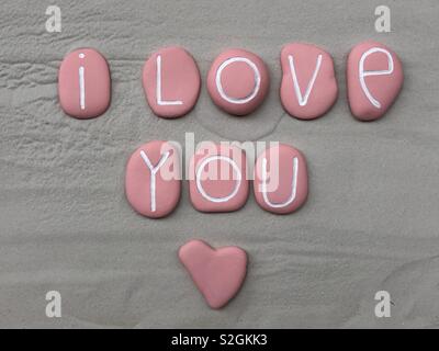 I love you with all my heart, conceptual composition with pink colored stones over white sand Stock Photo