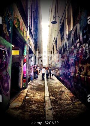 People or tourists I n a graffiti covered alleyway in Melbourne Stock Photo