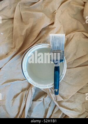 Paint brush resting on a tin of paint Stock Photo