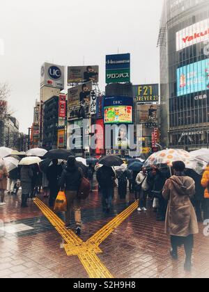 Famous Shibuya Scramble Crossing on a Rainy Day from Pedestrian Perspective Stock Photo