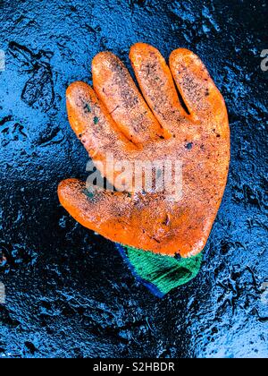 Discarded worker’s glove on wet road. Glasgow. Scotland. UK. Stock Photo