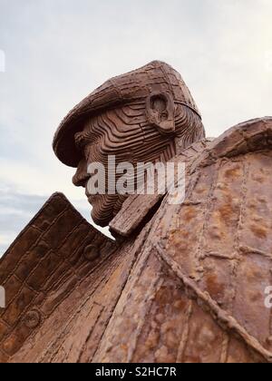 Head in profile of a giant sculpture in rusting steel by Ray Lonsdale, entitled Freddie Gilroy and the Belsen Stragglers located in North Bay, Scarborough, UK Stock Photo