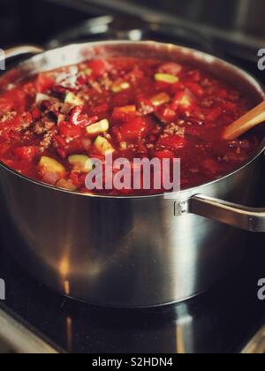 Homemade beef and vegetable chilli in a large stainless steel pot on stove Stock Photo