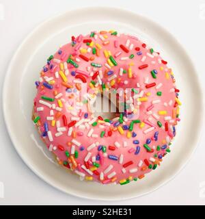 Top down view of a pink sprinkle donut. Stock Photo