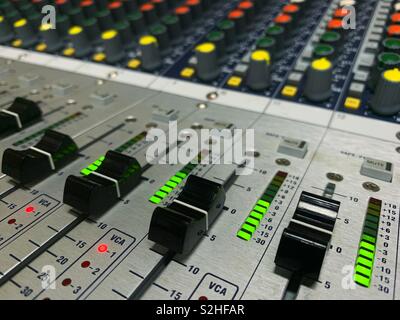 Faders and meters in action on an a modern alalog mixing console Stock Photo