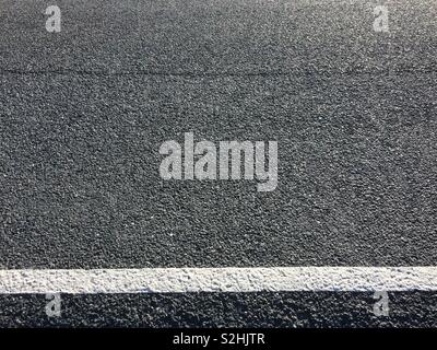 Close-up detail of asphalt road with white marking line Stock Photo